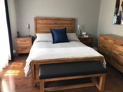 Banc de la collection Jules en érable massif avec coussin en vinyle noir au pied du lit modèle Montebello en bois