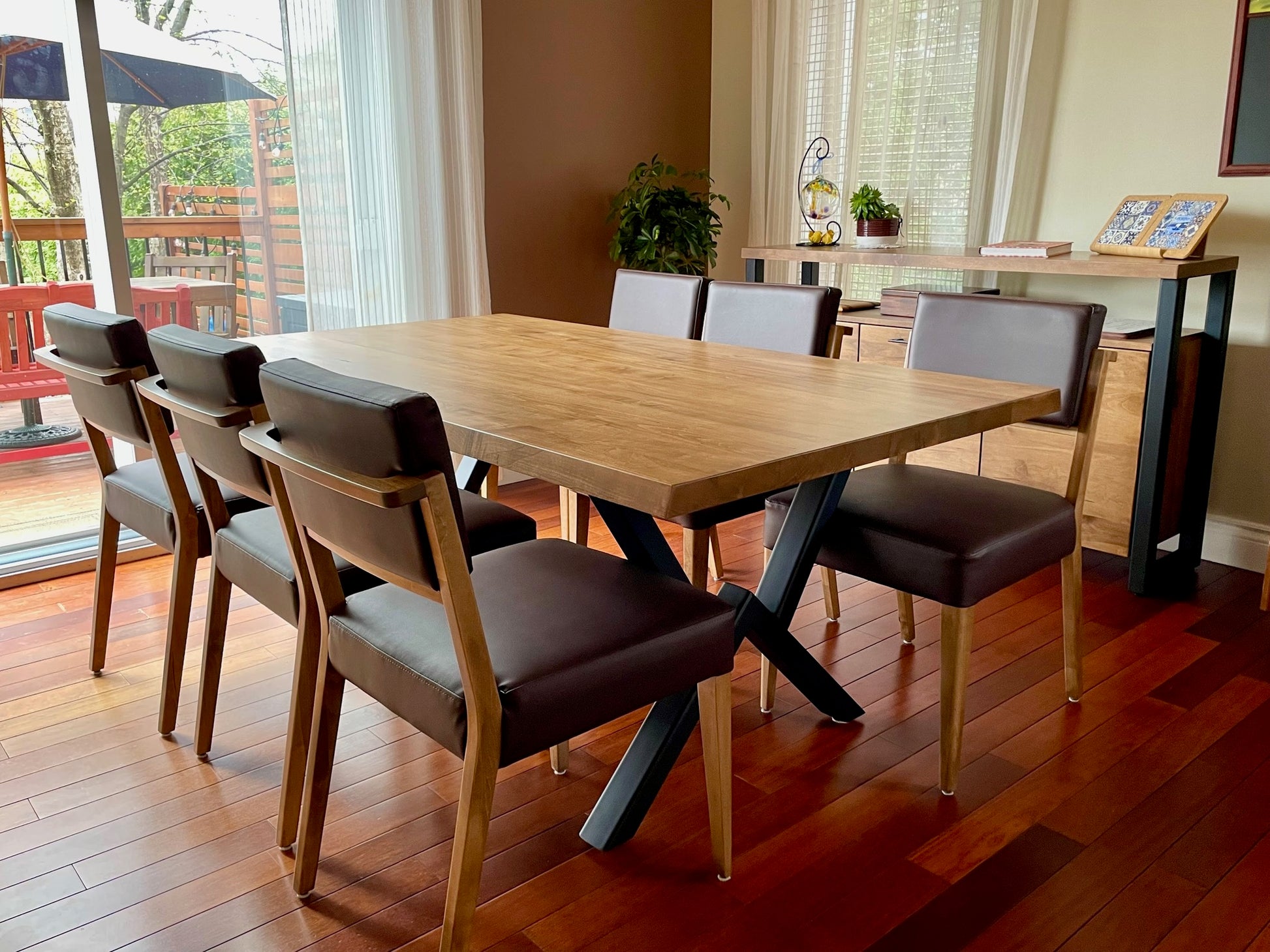 Table Roberval avec angle en biseau et chaises St-James en vinyle brun agencées au buffet Asbestos en érable massif et acier noir